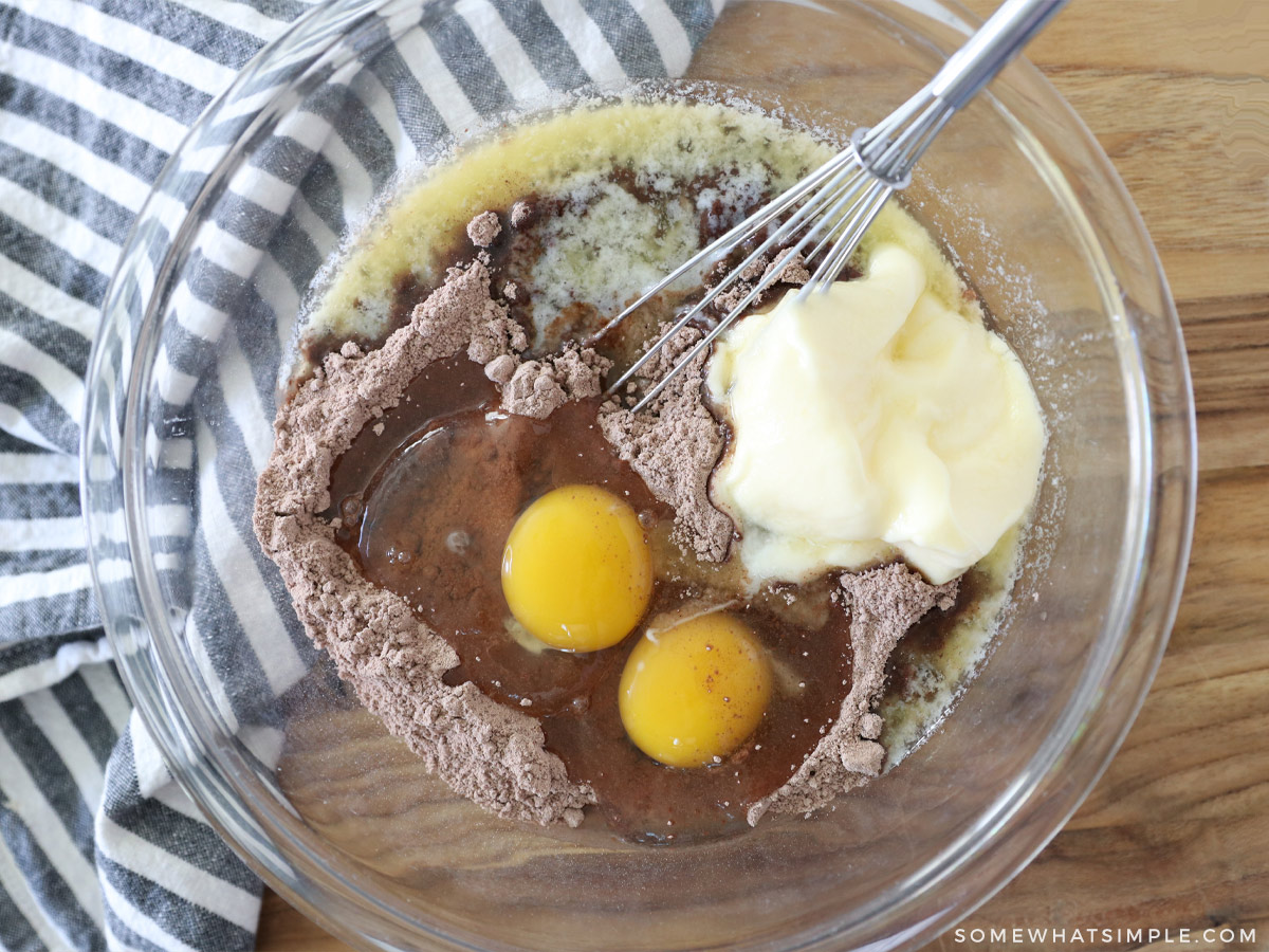 adding ingredients to a bowl to make chocolate cookies