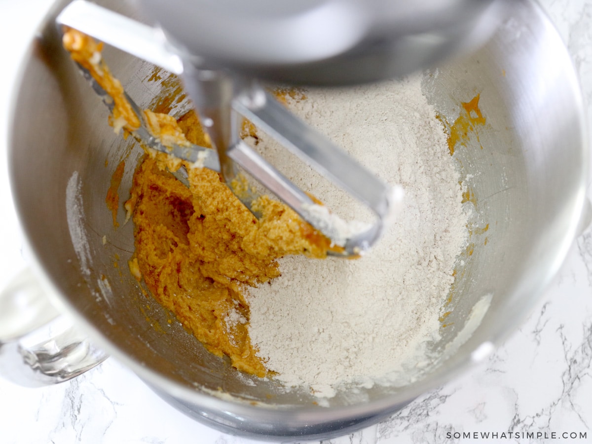 adding dry ingredients to wet ingredients for pumpkin sugar cookies