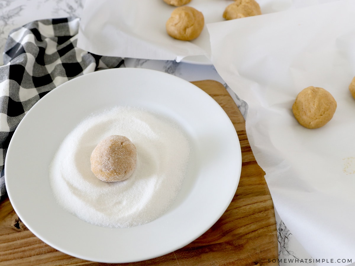 cookie dough being rolled in white sugar