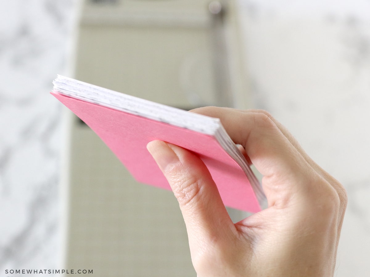 holding a stack of paper