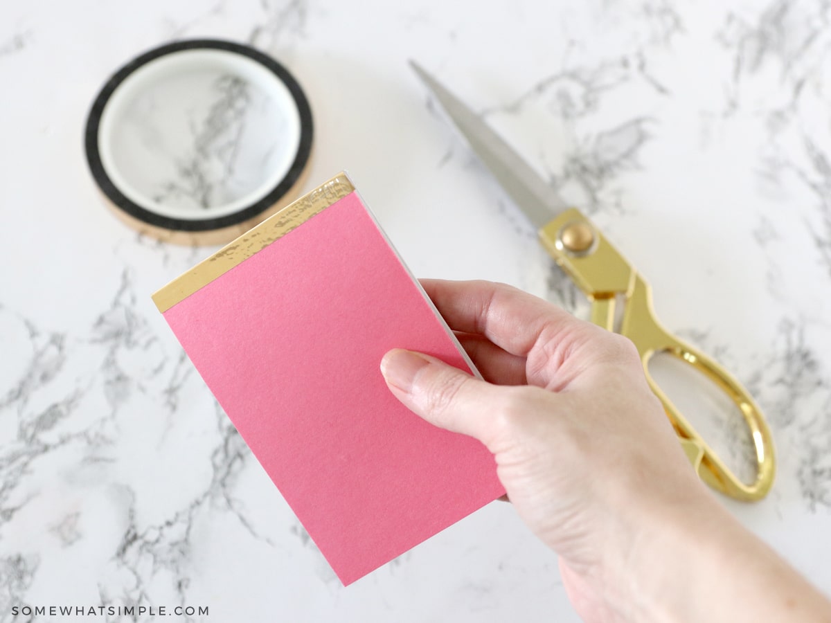 adding gold tape to a notepad