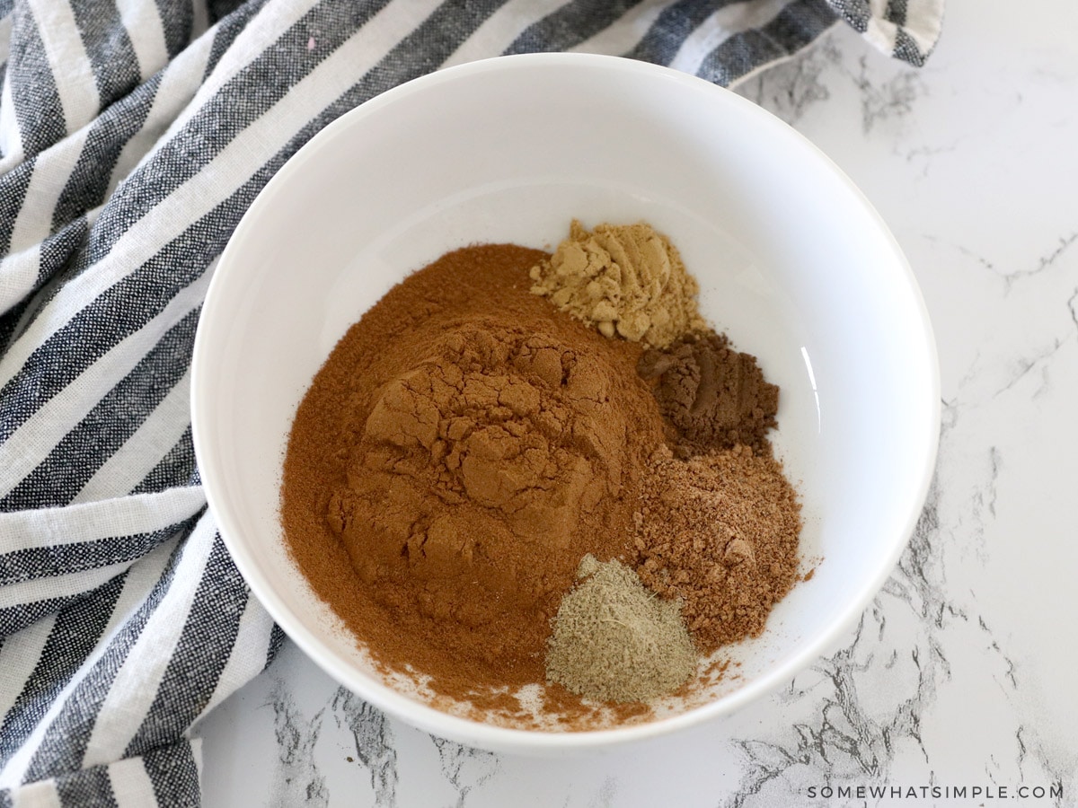 adding all ingredients for apple pie spice to a white bowl