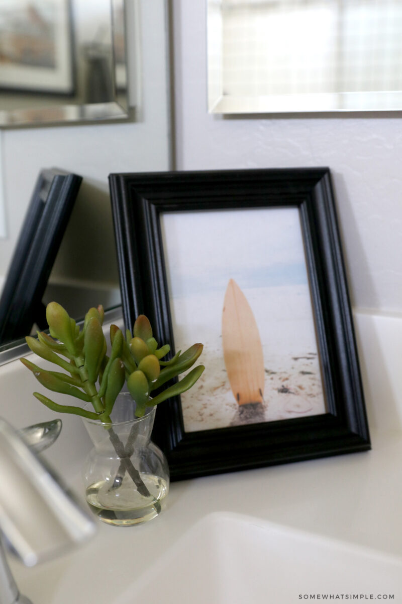 small black frame in corner of bathroom vanity