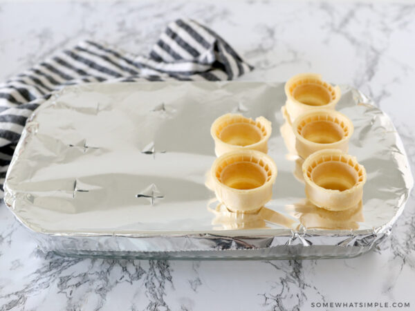 adding sugar cones to a sheet of foil over a casserole pan