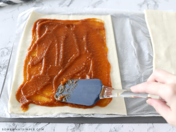 spreading pumpkin mixture onto puff pastry