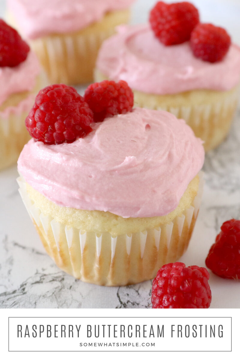 long image of vanilla cupcakes topped with raspberry buttercream frosting and fresh raspberries