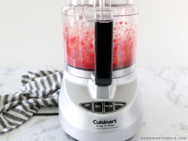 adding fresh raspberries to the food processor