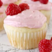 close up of a vanilla cupcake topped with raspberry buttercream frosting