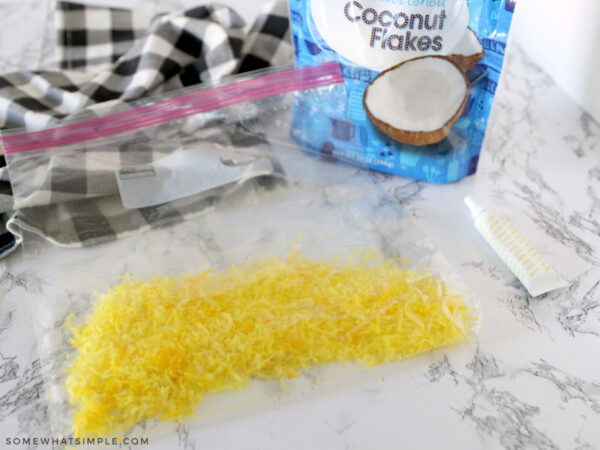 dying coconut flakes yellow in a ziplock bag