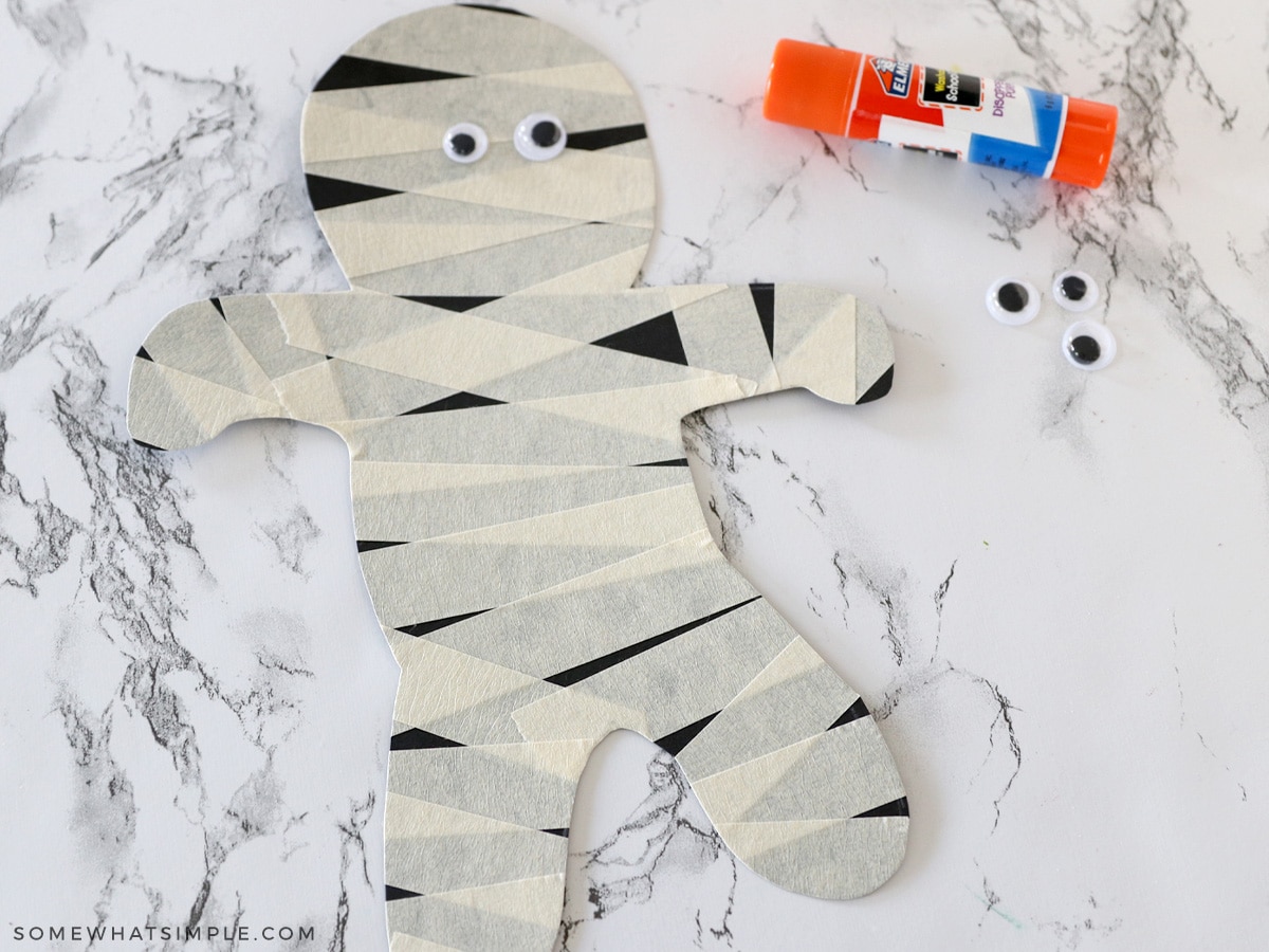 cutting out a paper mummy covered in masking tape