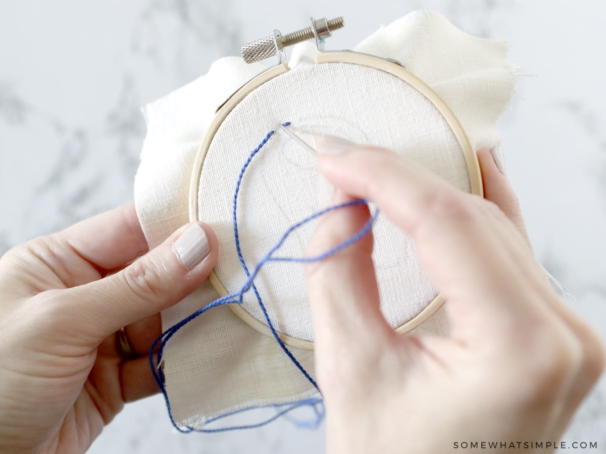 following a hand-drawn pattern on an embroidery hoop