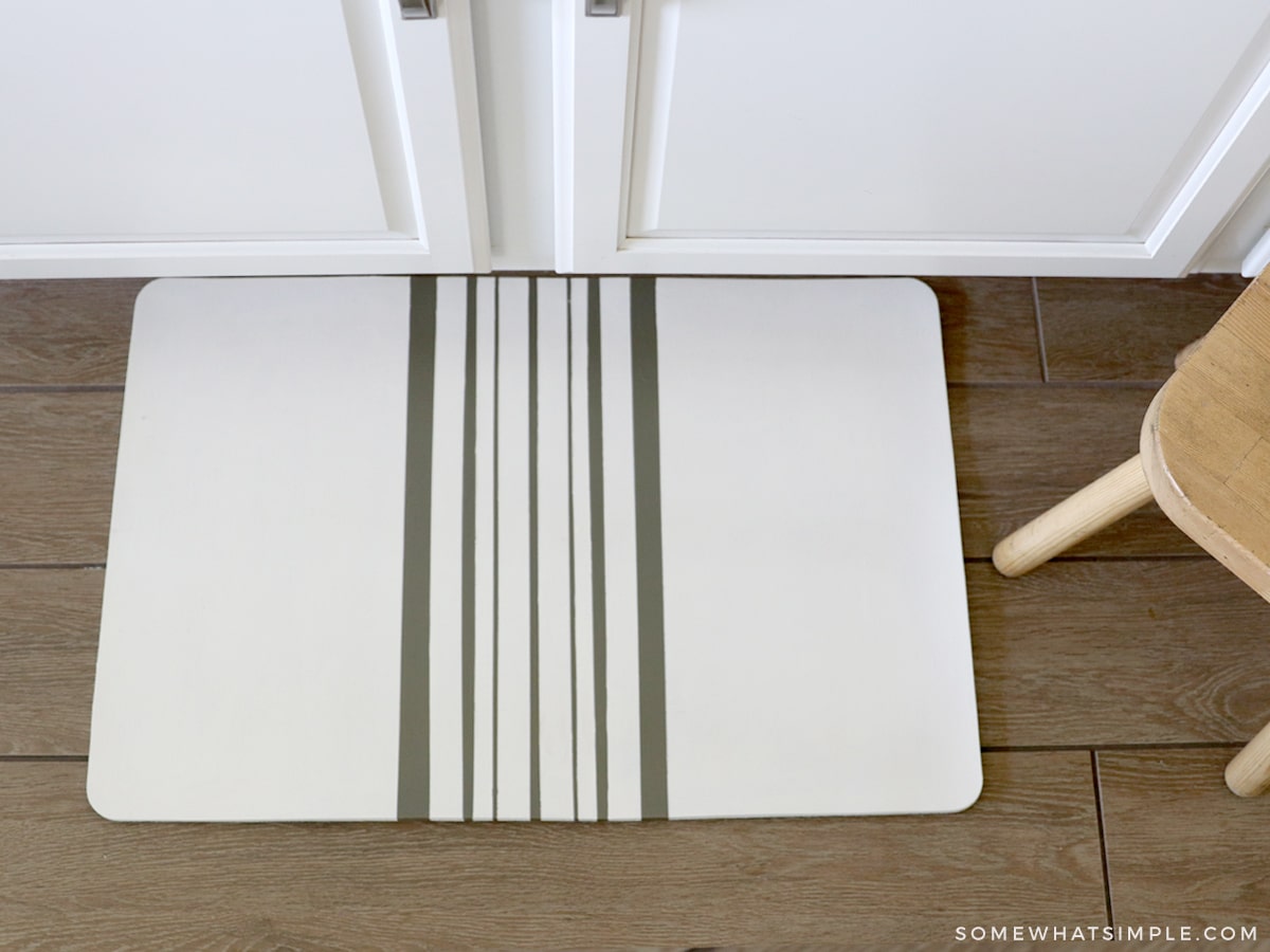 finished painted kitchen mat by a white cupboard and a wooden stool