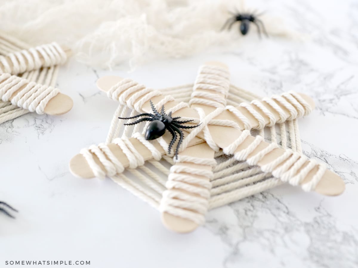 spider webs made from popsicle sticks and yarn