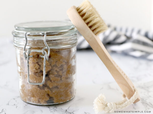 pumpkin sugar scrub in a jar with a bath brush next to it