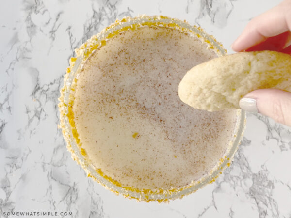 adding a cookie to the side of a cocktail glass