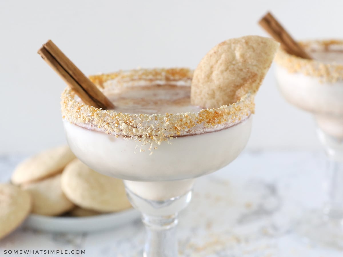 snickerdoodle mocktail with a cinnamon stick and broken cookie on the side of the glass