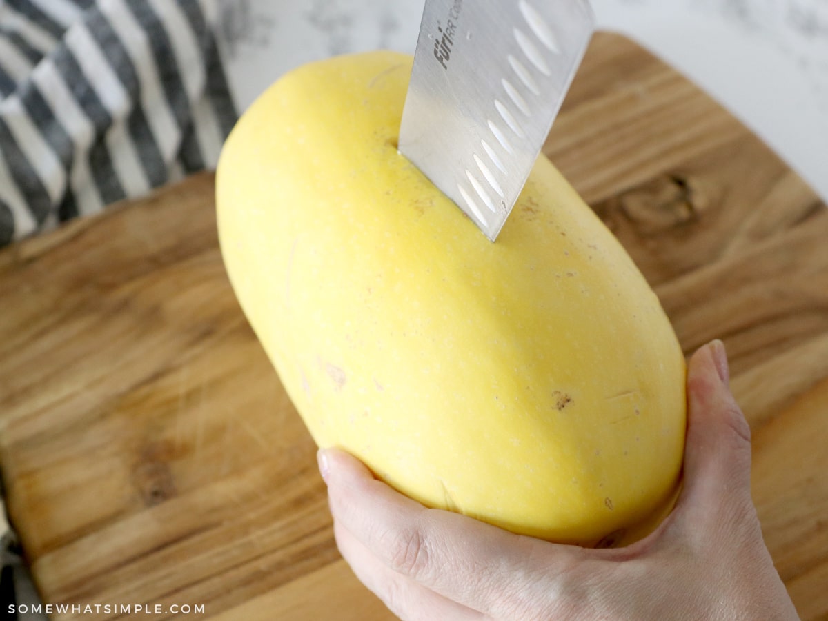 cutting a spaghetti squash with a large knife