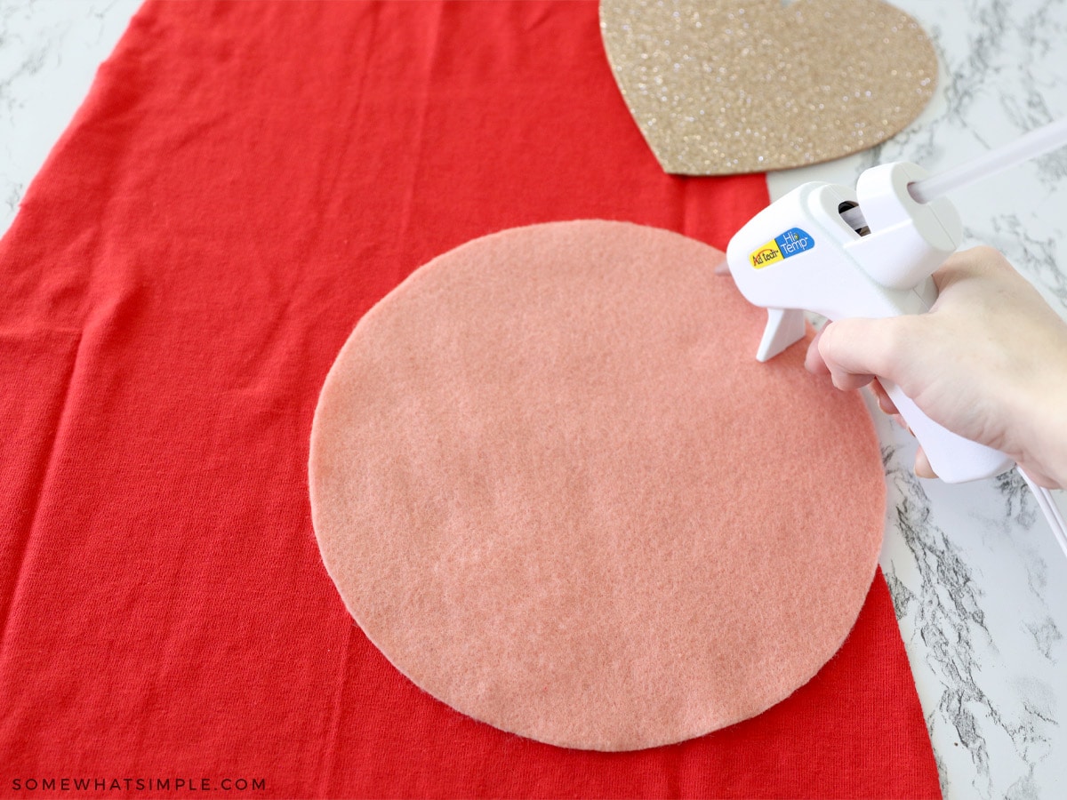 glueing a piece of felt onto a superhero cape