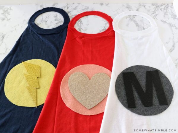 cute logos on the back of 3 superhero capes for kids