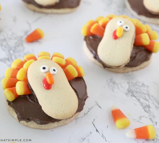 turkey cookies made with sugar cookies, chocolate frosting, milano cookies, and candy corn