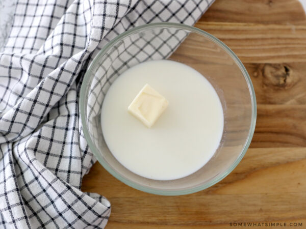 adding milk and butter to a bowl