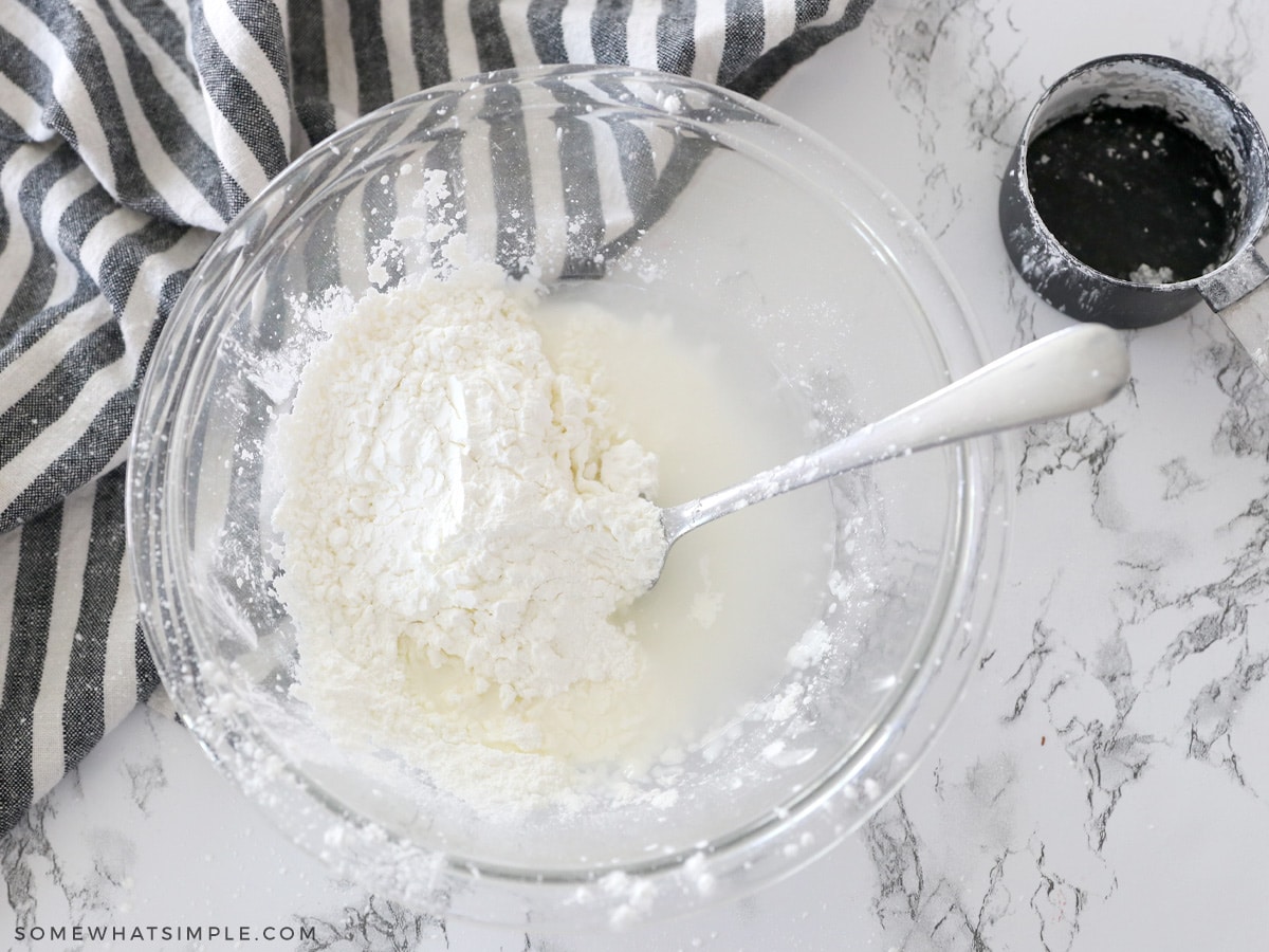 adding cornstarch to a bowl of water