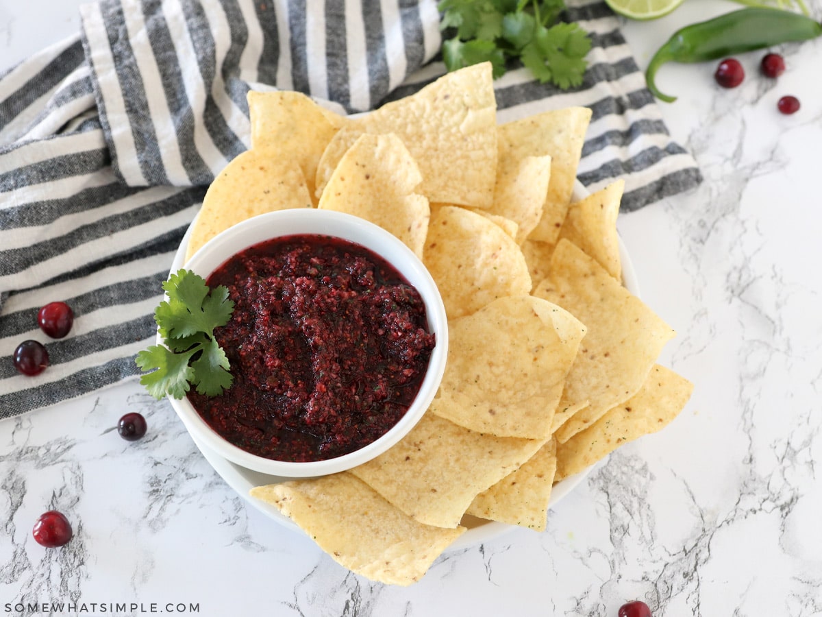 plate of chips with cranberry salsa in a small bowl