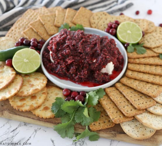 cranberry salsa surrounded by a plate of crackers