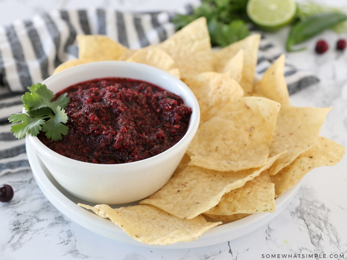 a small dish of cranberry salsa next to some chips