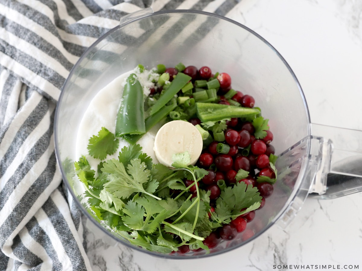 adding cranberry salsa ingredients to a food processor