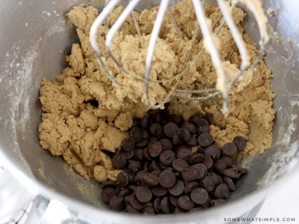 adding chocolate chips to cookie dough