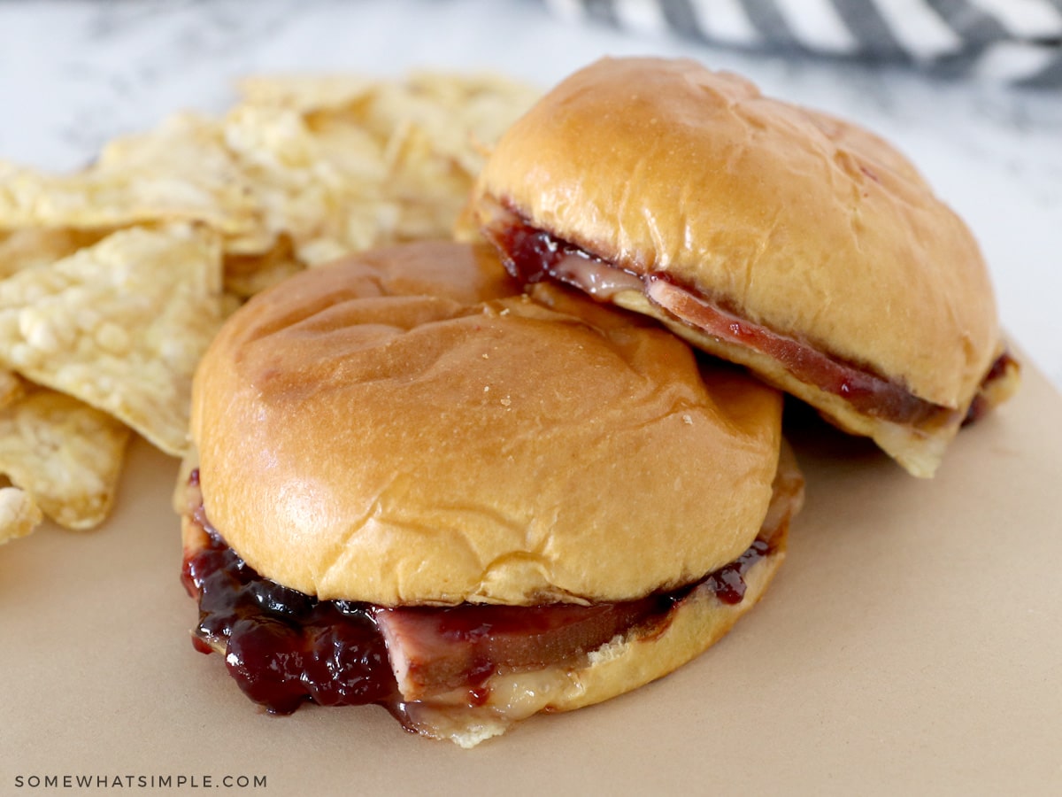 close up of a ham and jam sandwich on a brown piece of parchment paper