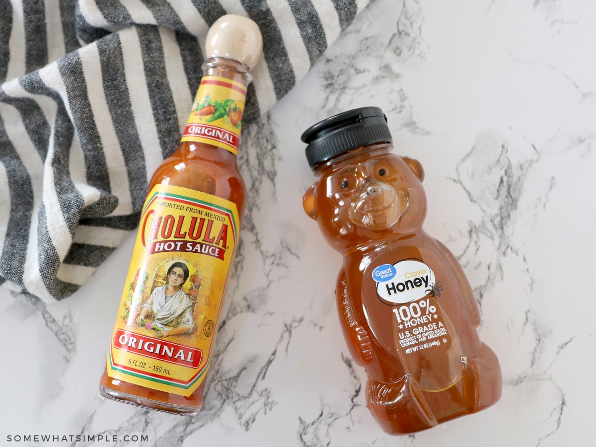 a jar of salsa and a bottle of honey laying flat on the counter