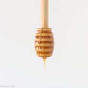hot honey dripping off a wooden honey spoon