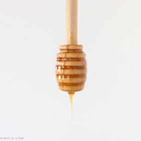 hot honey dripping off a wooden honey spoon