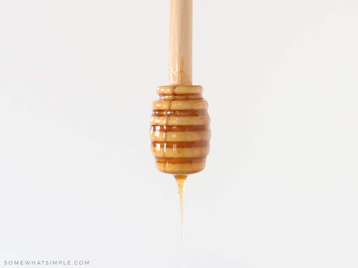 hot honey dripping off a wooden honey spoon