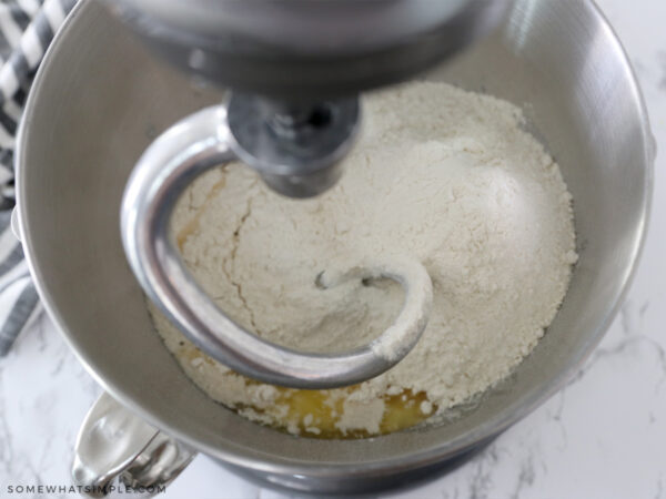 adding bread ingredients to a mixer