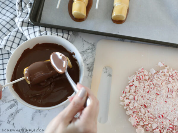 dipping marshmallow wands into milk chocolate