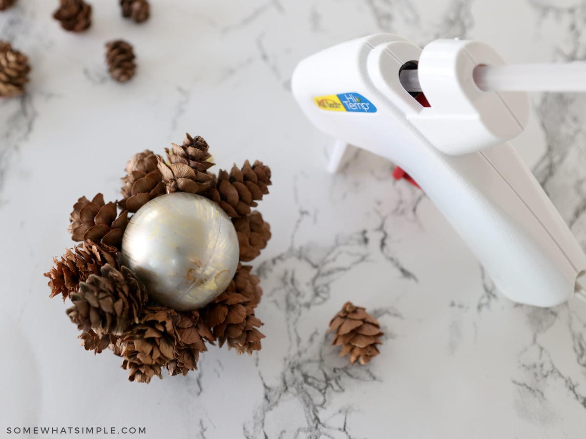 glueing pinecones onto an ornament