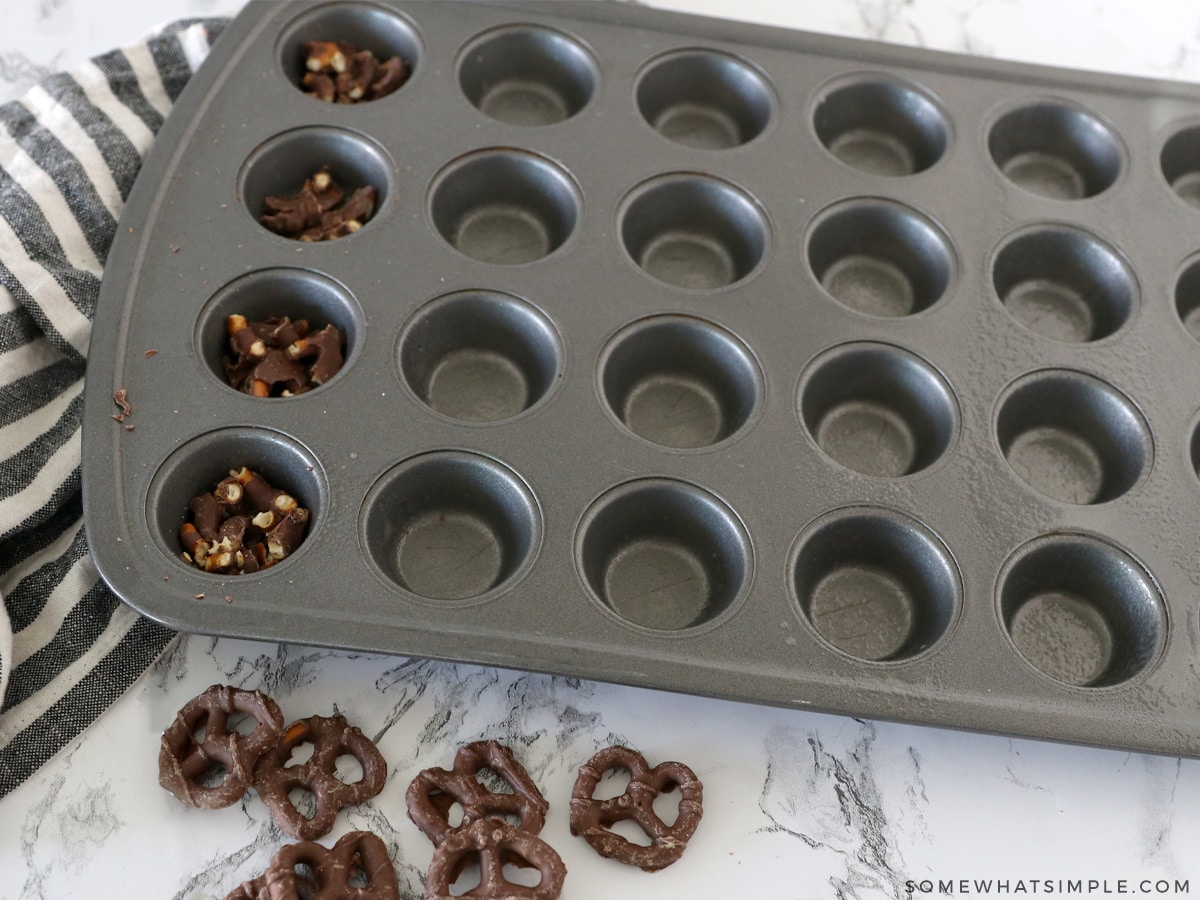 breaking chocolate pretzels in a mini muffin tin