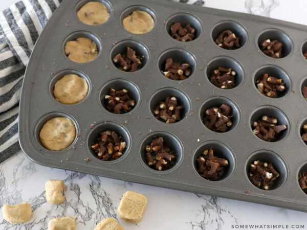 adding cookie dough on top of chocolate pretzels