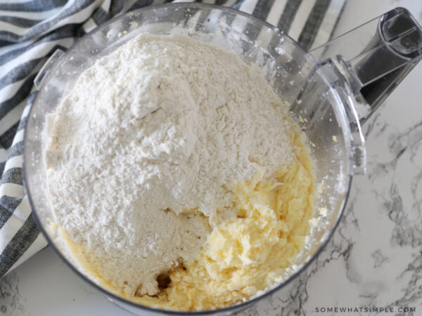 adding flour to shortbread cookie dough