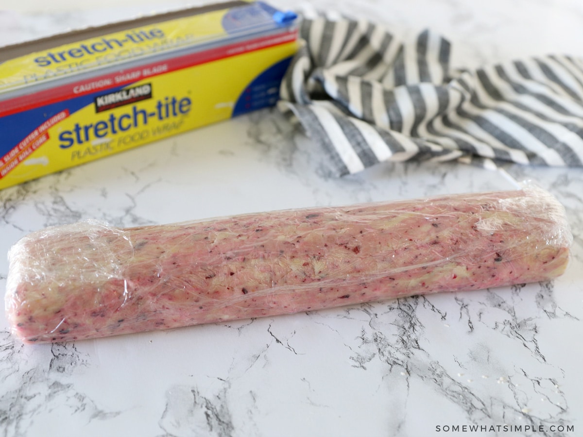 wrapping a log of shortbread dough in plastic wrap