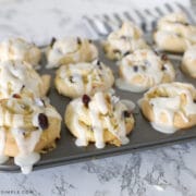 muffin tin with cranberry orange sweet rolls in each cup