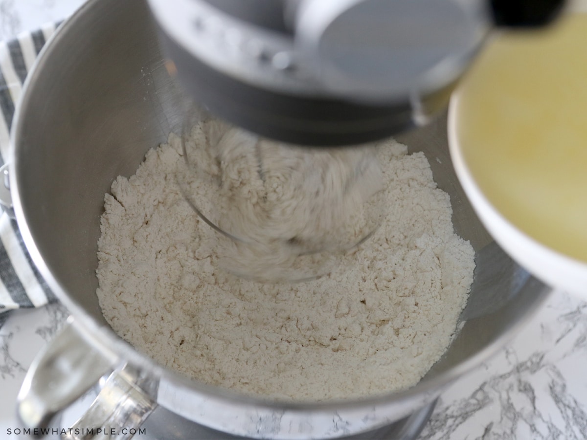 adding melted butter to a flour mixture