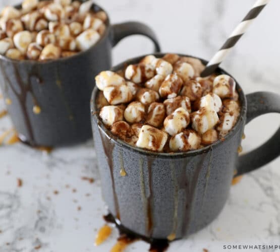 2 mugs filled with creamy hot cocoa