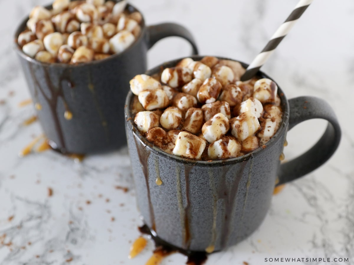 2 mugs filled with creamy hot cocoa