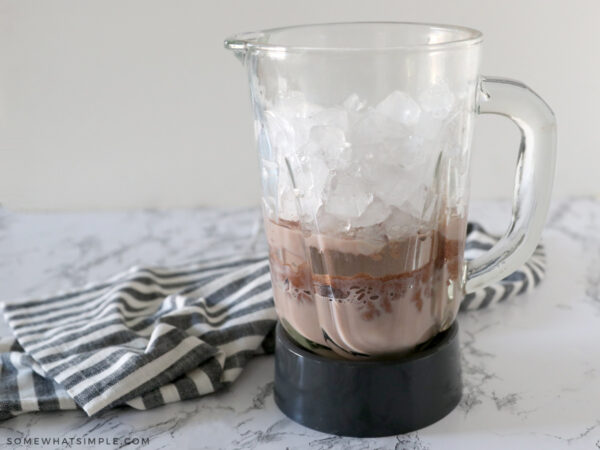 adding frozen hot chocolate ingredients to a blender