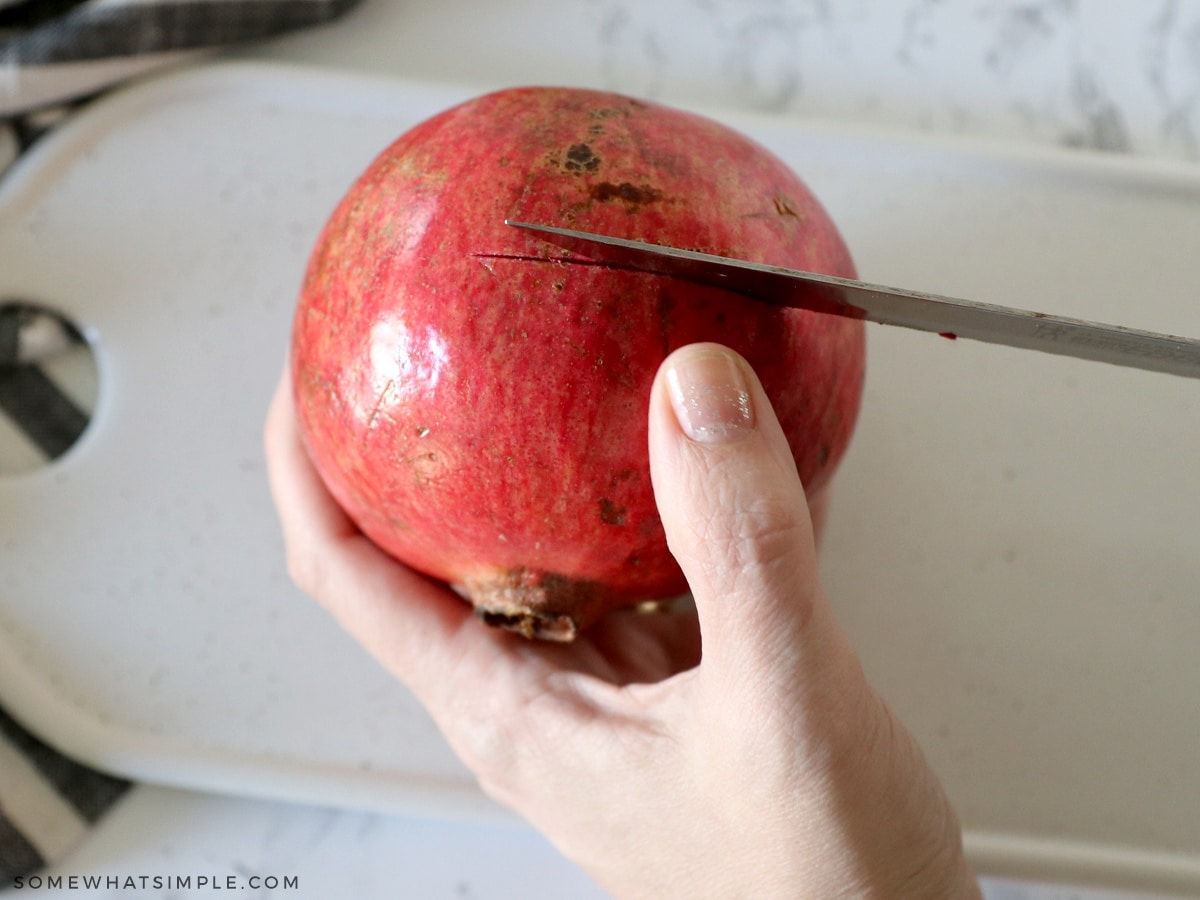 slicing a pomegranate with a sharp knife