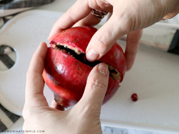 pulling a cut pomegranate in half
